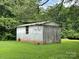 Exterior view of the property's storage outbuilding on a large lawn, providing great storage at 506 Hearne Farm Rd, Mount Gilead, NC 27306