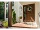 Close-up view of a welcoming front door with brick entryway, adorned with a wreath and potted plants at 6639 Camp Creek Rd, Lancaster, SC 29720