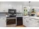 Bright kitchen showcases white cabinets, stainless steel appliances, and view to the living space at 6639 Camp Creek Rd, Lancaster, SC 29720
