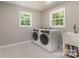 The laundry room has white front-loading washer and dryer, a sink, and windows at 6639 Camp Creek Rd, Lancaster, SC 29720