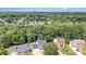 An aerial view of the neighborhood showcasing the tree coverage and proximity to the city skyline at 6930 Culloden More Ct, Charlotte, NC 28217