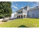 Landscaped backyard with a covered patio, trampoline, and expansive grassy area at 6930 Culloden More Ct, Charlotte, NC 28217