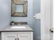 Charming powder room features modern sink and faucet, vanity with storage, and decorative mirror at 6930 Culloden More Ct, Charlotte, NC 28217