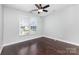 Simple bedroom with dark hardwood floors, a large window, and overhead fan at 6930 Culloden More Ct, Charlotte, NC 28217
