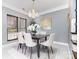Elegant dining room with a chandelier, gray walls, and a modern table setting at 6930 Culloden More Ct, Charlotte, NC 28217