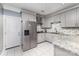 Contemporary kitchen featuring gray cabinets, granite countertops, and stainless steel refrigerator at 6930 Culloden More Ct, Charlotte, NC 28217