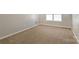 Bedroom with neutral carpet and walls featuring a window at 8351 Rolling Meadows Ln, Huntersville, NC 28078