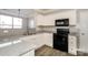 Kitchen featuring granite counters, white cabinets, hardwood floors, and black appliances at 8351 Rolling Meadows Ln, Huntersville, NC 28078
