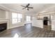 Bright living room featuring hardwood floors, a fireplace, and a seamless open-concept kitchen at 8351 Rolling Meadows Ln, Huntersville, NC 28078