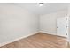 Inviting bedroom with wood-look floors, white trim, and a door leading to other rooms at 1019 S Main St, Granite Quarry, NC 28146