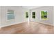 Bright, empty bedroom with wood-look floors and three windows letting in lots of natural light at 1019 S Main St, Granite Quarry, NC 28146