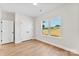 Bedroom with wood-look flooring, white walls, double door closet, and a window overlooking the front yard at 1019 S Main St, Granite Quarry, NC 28146