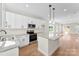 Well-lit kitchen with a granite island, modern appliances, and open layout to the living room at 1019 S Main St, Granite Quarry, NC 28146
