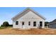 Back exterior view of a new home with vertical siding, showing door and window placements at 1019 S Main St, Granite Quarry, NC 28146