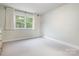 An empty bedroom with a bright window and neutral carpet at 12101 Ranburne Rd, Mint Hill, NC 28227