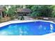 Backyard pool with patio area, outdoor seating, and lush landscaping at 12101 Ranburne Rd, Mint Hill, NC 28227