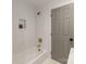 Bright bathroom featuring a white tiled shower with golden hardware and modern shelving at 1314 Ordermore Ave, Charlotte, NC 28203
