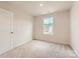 Bright bedroom featuring plush carpet, a large window, and neutral decor, creating a peaceful retreat at 143 Astor St, Troutman, NC 28166