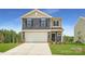 Charming two-story home featuring a two-car garage, manicured lawn, and classic architectural details at 143 Astor St, Troutman, NC 28166