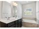 Bathroom features double sink vanity, soaking tub with tile surround, and a bright window at 2040 Dornoch Rd, Tega Cay, SC 29708