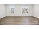 Bright bedroom featuring two windows offering neighborhood views and wood-look flooring at 2040 Dornoch Rd, Tega Cay, SC 29708