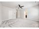 Large bedroom features plush carpeting, ceiling fan, and doors to closets and en-suite bathroom at 2040 Dornoch Rd, Tega Cay, SC 29708