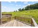 Wooden deck showcasing a scenic view of a grassy hill and vibrant greenery at 2040 Dornoch Rd, Tega Cay, SC 29708