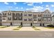 Stylish townhome exteriors showcasing stone accents, complementary siding, and individual garages under a bright sky at 2040 Dornoch Rd, Tega Cay, SC 29708