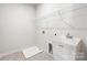 Functional laundry area featuring a utility sink, wire shelving, and tile flooring at 2040 Dornoch Rd, Tega Cay, SC 29708