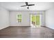 Airy living room features sleek flooring, neutral paint, fan and sliding glass door at 2040 Dornoch Rd, Tega Cay, SC 29708