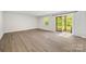 Bright living room with wood flooring, sliding glass door with backyard views, and neutral walls at 2040 Dornoch Rd, Tega Cay, SC 29708