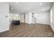 Open-concept living room with wood-look flooring, kitchen island, and staircase access at 2040 Dornoch Rd, Tega Cay, SC 29708