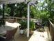 Relaxing back porch features a wooden railing, plants, seating, and shade at 257 Rolling View Dr, New London, NC 28127