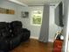 Living room with hardwood floors, a large mounted tv, and modern seating at 257 Rolling View Dr, New London, NC 28127