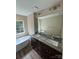 Bathroom featuring a soaking tub and a double sink vanity with a large mirror at 268 Hatley Ne Cir, Concord, NC 28025