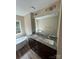 Bathroom featuring a soaking tub and a double sink vanity with a large mirror at 268 Hatley Ne Cir, Concord, NC 28025