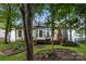 Landscaped backyard featuring a wood deck, brick chimney, and lush green lawn at 3422 Balsam Tree Dr, Charlotte, NC 28269