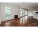 Open-concept living room with hardwood floors, a fireplace, and access to the kitchen area at 3422 Balsam Tree Dr, Charlotte, NC 28269