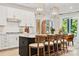 Beautiful kitchen with a black island, white cabinets, light countertops, and stunning gold light fixtures at 4010 Caymen Bay Ct, Tega Cay, SC 29708
