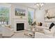 Bright living room featuring a fireplace, white sofas, and large windows offering natural light at 4010 Caymen Bay Ct, Tega Cay, SC 29708