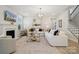 Bright living room featuring plush white couches, fireplace, decorative lighting, and neutral tones at 4010 Caymen Bay Ct, Tega Cay, SC 29708
