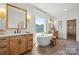 Bright bathroom featuring a soaking tub, dual vanities, and modern fixtures at 5361 Mint Harbor Way # 0301, Charlotte, NC 28269