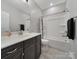 Well-lit bathroom with dark vanity, large mirror, and a shower-tub combo with black shower curtain at 537 Lincoln Quarters Ln, Fort Mill, SC 29708