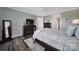 The bedroom features dark wood floors and trim, complemented by a large television and decorative wall art at 537 Lincoln Quarters Ln, Fort Mill, SC 29708