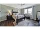 A spacious bedroom with wood floors, a ceiling fan, and a four-poster bed with two side tables and lamps at 537 Lincoln Quarters Ln, Fort Mill, SC 29708