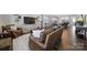 Open-concept living room showcasing a large leather sofa, stylish decor, and a modern kitchen at 537 Lincoln Quarters Ln, Fort Mill, SC 29708