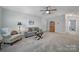 Living room featuring gray carpet, a ceiling fan, a sofa, and a side chair with an ottoman at 537 Lincoln Quarters Ln, Fort Mill, SC 29708