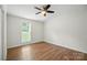 Bright bedroom with hardwood floors, a ceiling fan, and a large window offering ample natural light at 8106 Strawberry Point Dr, Charlotte, NC 28215