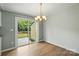 Dining area with sliding glass door to deck, light fixture, and wood floors at 8106 Strawberry Point Dr, Charlotte, NC 28215