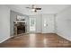 Open living room featuring a stone fireplace, ceiling fan, and hardwood floors at 8106 Strawberry Point Dr, Charlotte, NC 28215